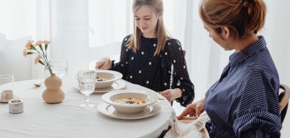 A serene scene of a mother and daughter dining together in a bright, cozy setting.