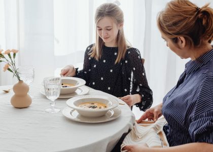 A serene scene of a mother and daughter dining together in a bright, cozy setting.